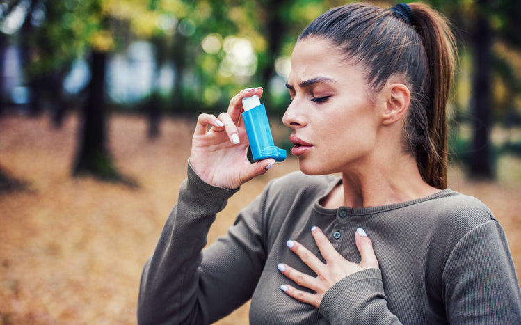 woman using inhaler for her asthma