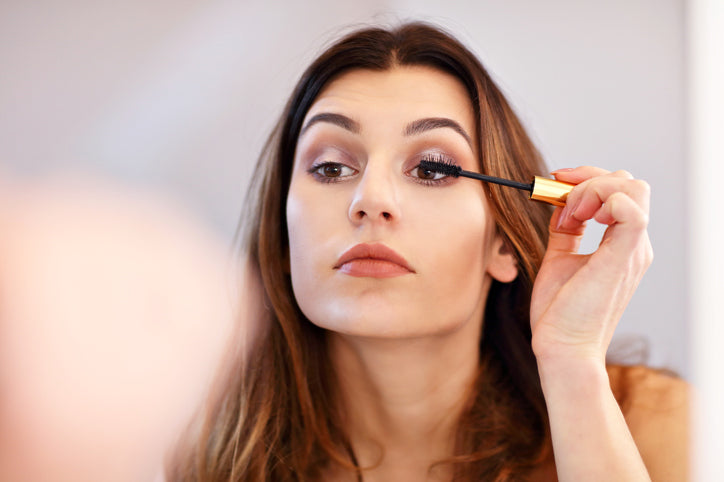 woman putting on mascara
