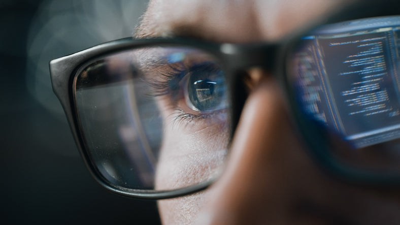 close-up of person wearing glasses and looking at computer screen