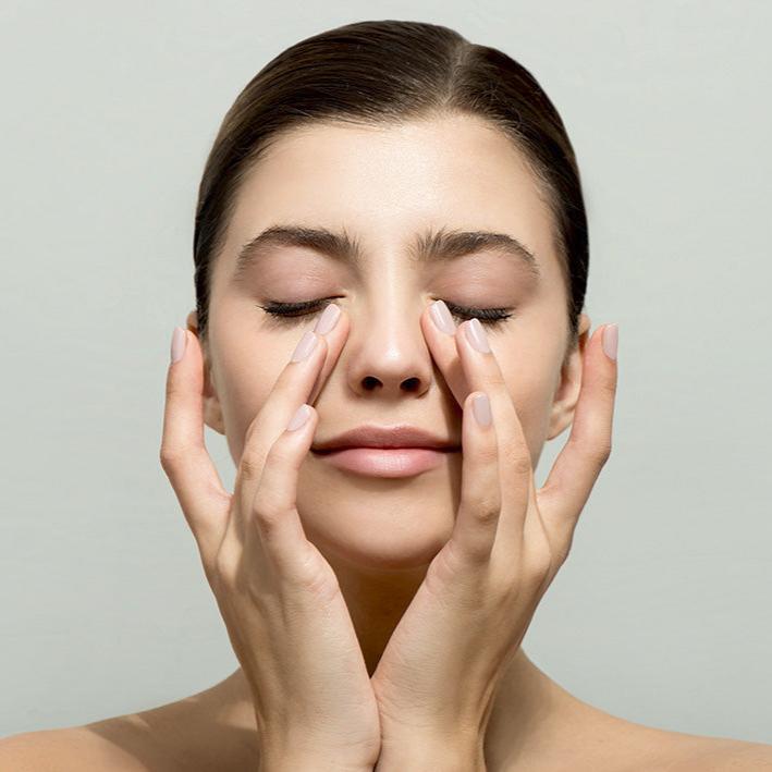 woman massaging eyes for natural dry eye relief and relaxation supporting benefits of Wizard Research heated dry eye mask