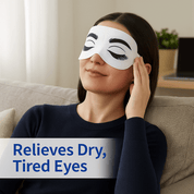 Woman relaxing on couch wearing Wizard Research single-use self heated eye mask for dry eye relief,
